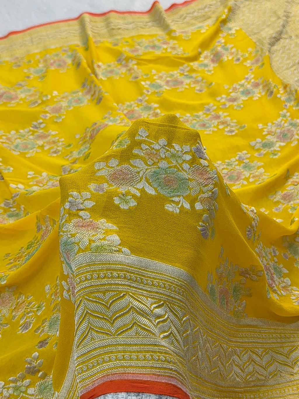 Banarasi Pure Khaddi Chiffon Saree  with Silver Zari Work In Floral Jaal Design with Meenakari by handbrush Yellow Colour with orange edge